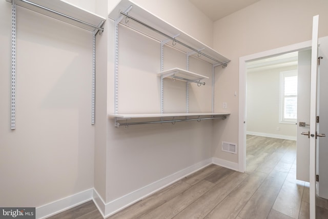 walk in closet with visible vents and wood finished floors