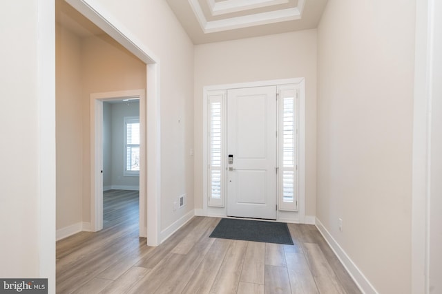 foyer entrance featuring visible vents, light wood-style floors, and baseboards