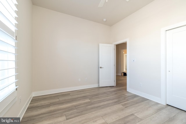 unfurnished bedroom featuring a ceiling fan, light wood-style floors, and baseboards