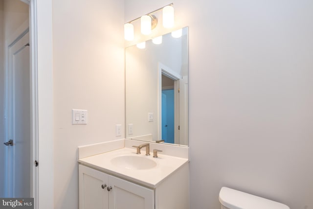 half bathroom featuring toilet and vanity