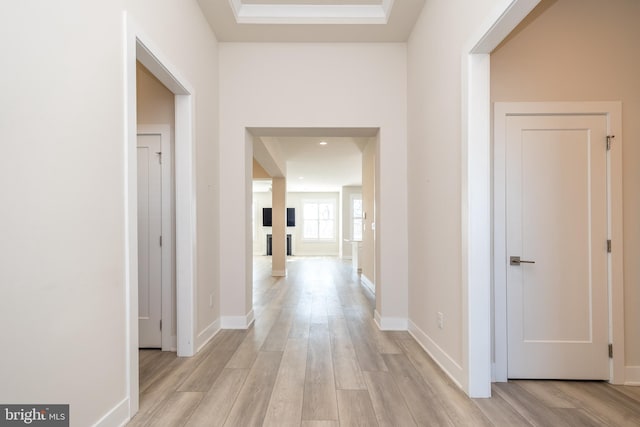 corridor with light wood-style floors and baseboards