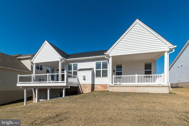 back of property featuring a lawn and covered porch