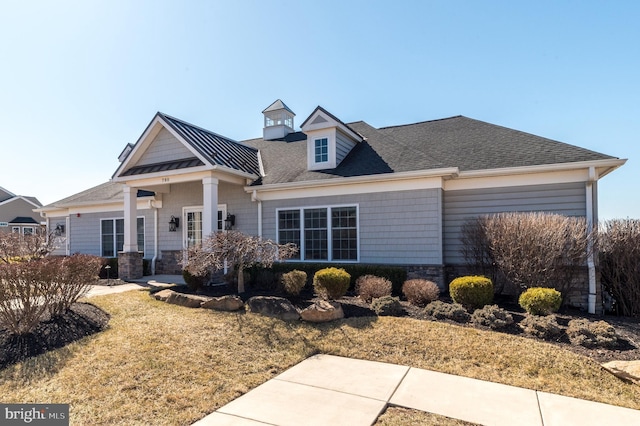 view of front of house featuring stone siding and roof with shingles