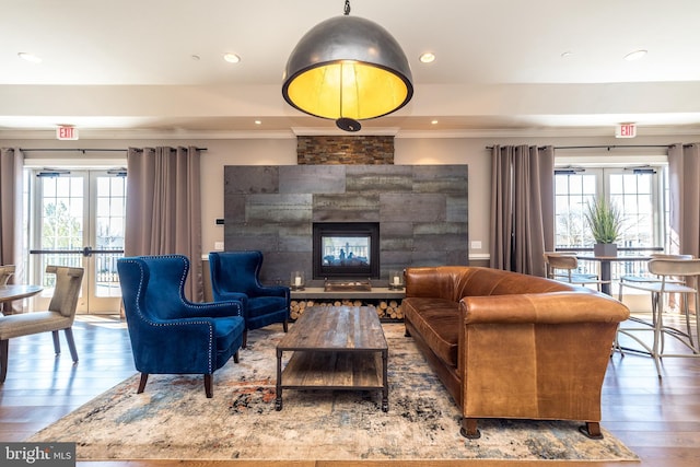 living room with french doors, a healthy amount of sunlight, a fireplace, and hardwood / wood-style flooring