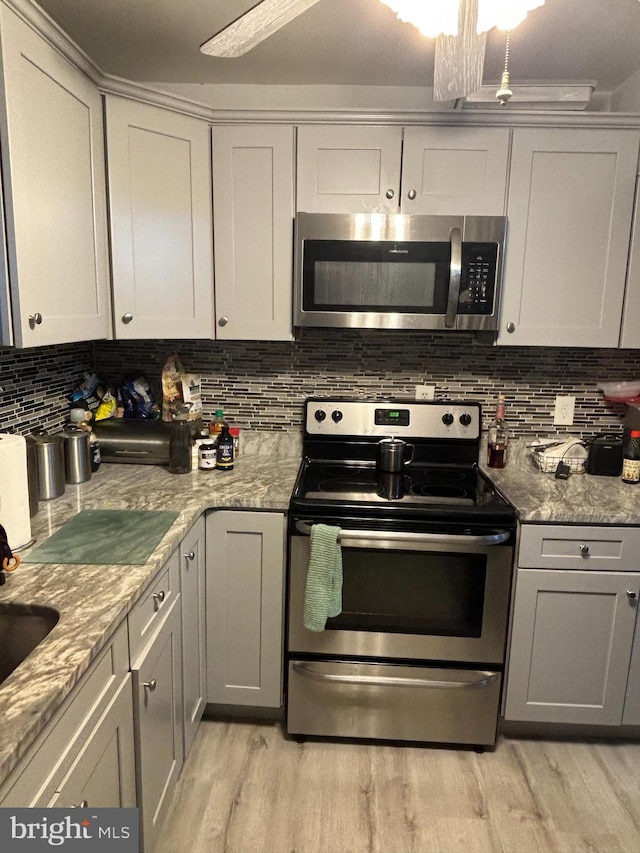 kitchen with decorative backsplash, light hardwood / wood-style floors, and stainless steel appliances