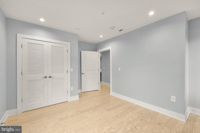 unfurnished bedroom featuring light hardwood / wood-style floors and a closet