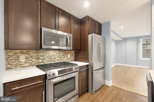 kitchen featuring backsplash, dark brown cabinetry, light hardwood / wood-style flooring, and appliances with stainless steel finishes