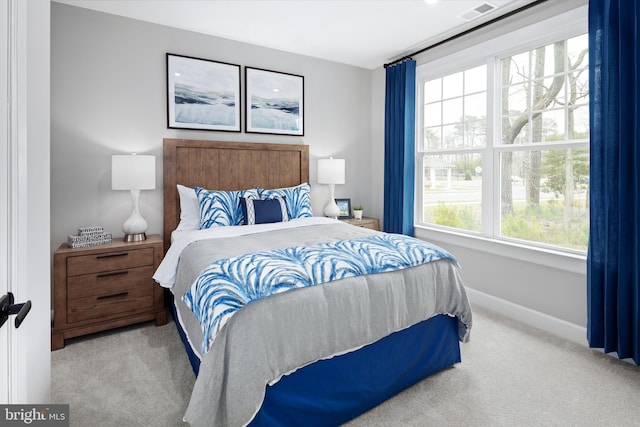 bedroom with light carpet and multiple windows