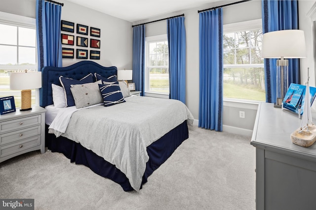 bedroom with light colored carpet and multiple windows