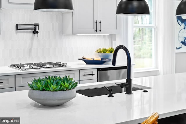 kitchen featuring white cabinets, decorative backsplash, sink, and stainless steel gas stovetop