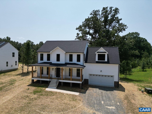 view of front of home featuring a front lawn, a porch, and a garage