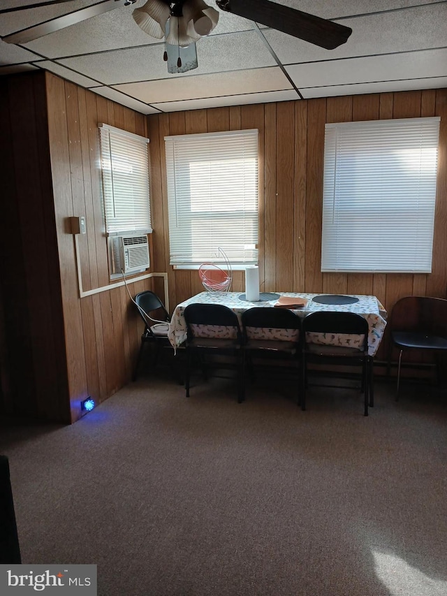 dining room featuring carpet, ceiling fan, wooden walls, and cooling unit