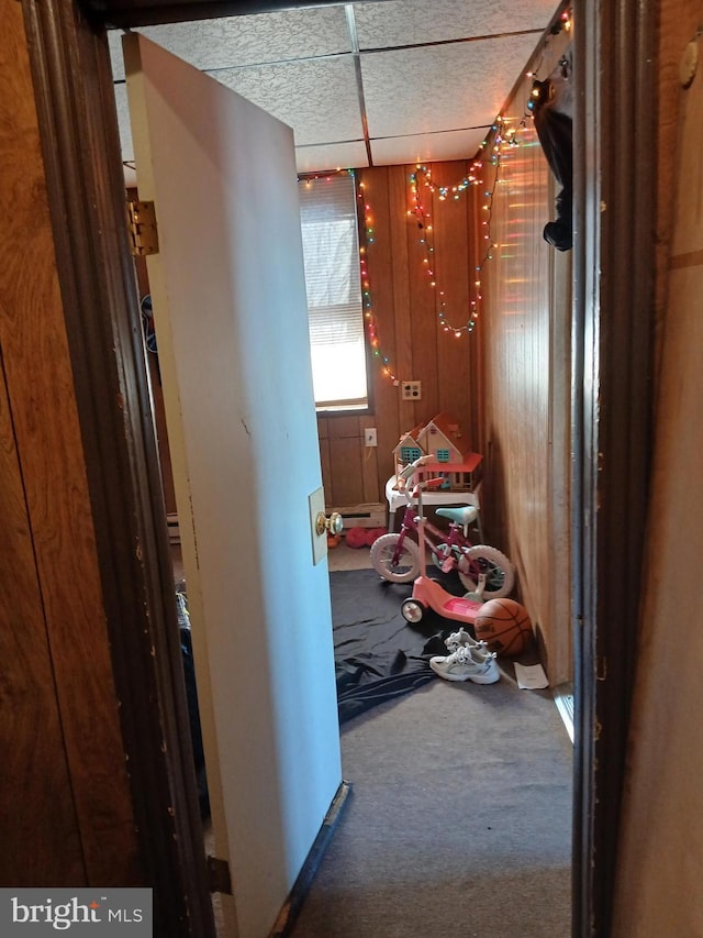 hallway featuring a paneled ceiling and carpet floors