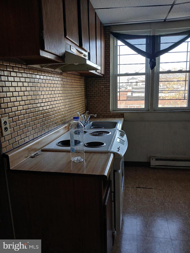 kitchen featuring a drop ceiling, tasteful backsplash, dark brown cabinetry, and a baseboard heating unit