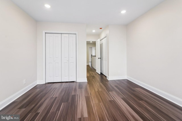 unfurnished bedroom featuring a closet and dark hardwood / wood-style floors