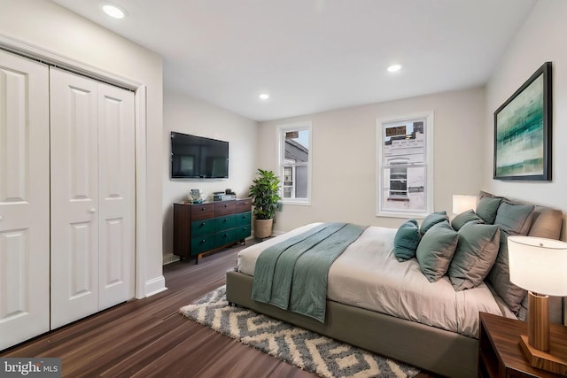 bedroom with dark hardwood / wood-style floors and a closet