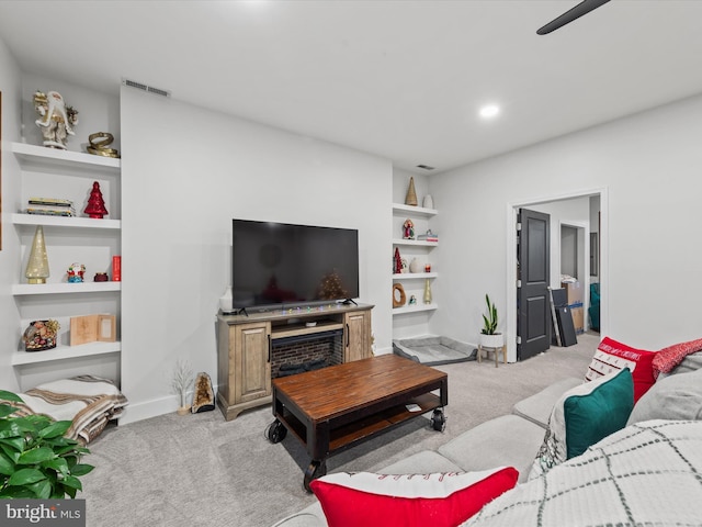 living room featuring built in shelves and light colored carpet