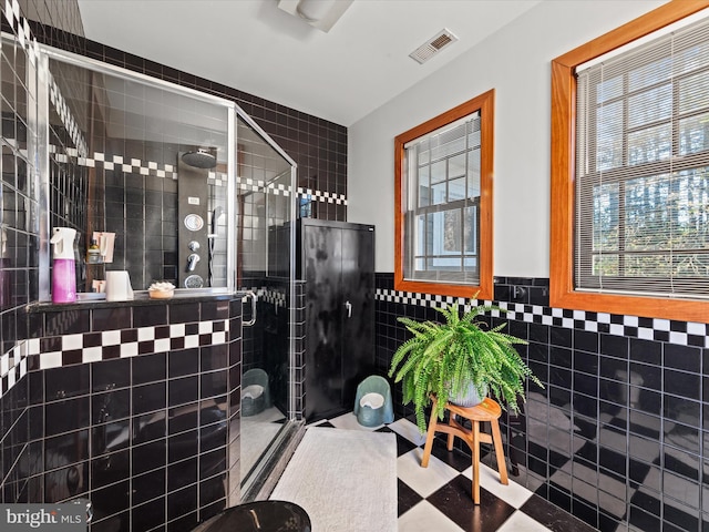 bathroom with an enclosed shower and tile walls