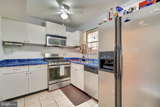 kitchen featuring white cabinets, sink, light tile patterned floors, and stainless steel appliances