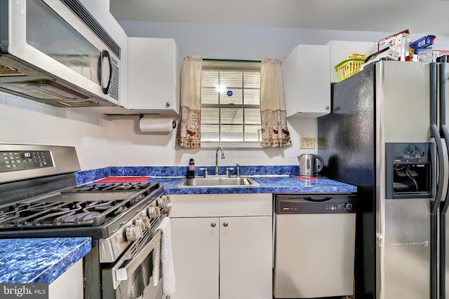 kitchen with white cabinets, sink, stainless steel appliances, and tasteful backsplash