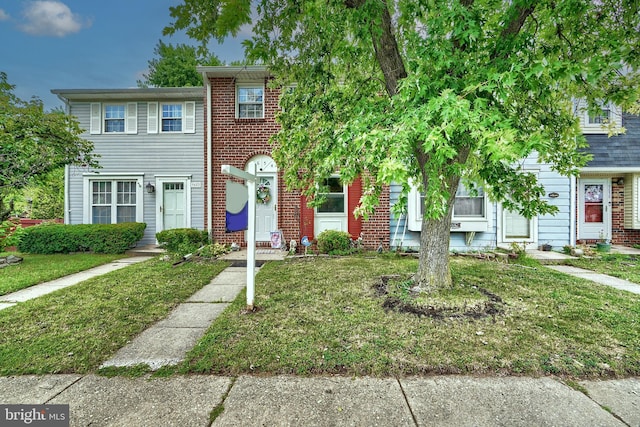 townhome / multi-family property featuring a front lawn