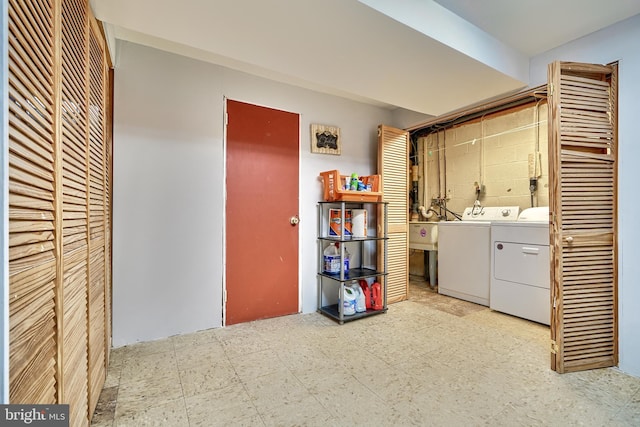 clothes washing area featuring separate washer and dryer and sink