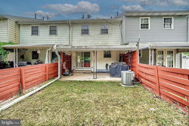 back of property featuring a lawn and central air condition unit