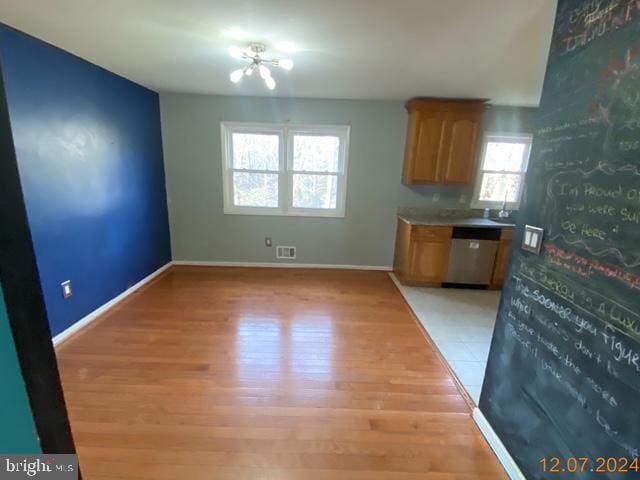 kitchen with a chandelier, dishwasher, and light hardwood / wood-style floors