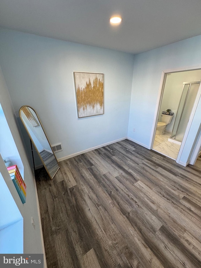 interior space with ensuite bathroom and dark hardwood / wood-style flooring