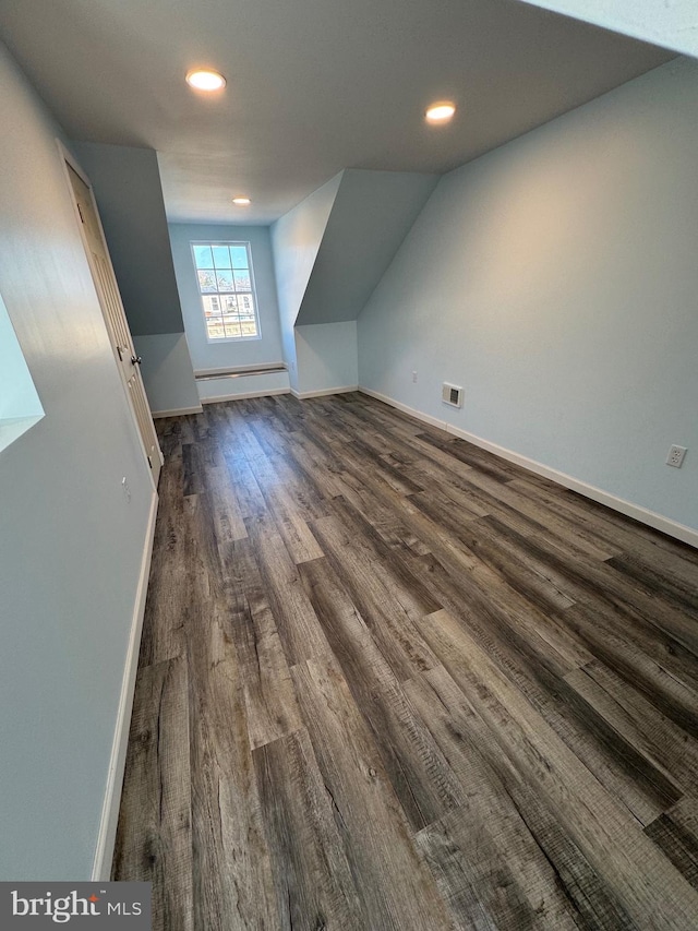 bonus room with lofted ceiling, a baseboard radiator, and dark hardwood / wood-style floors