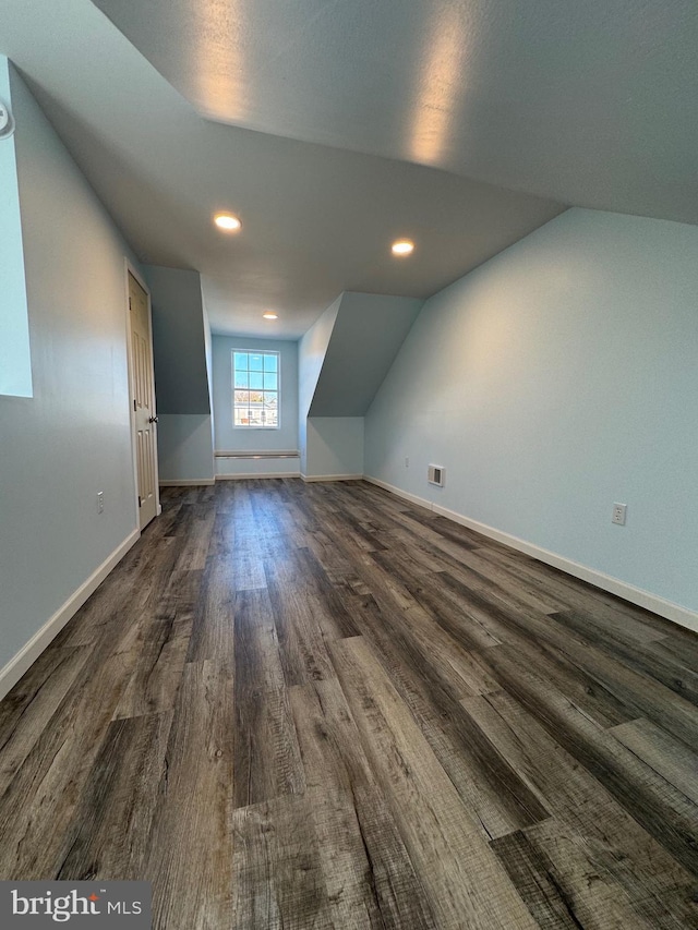 bonus room with dark hardwood / wood-style floors and vaulted ceiling