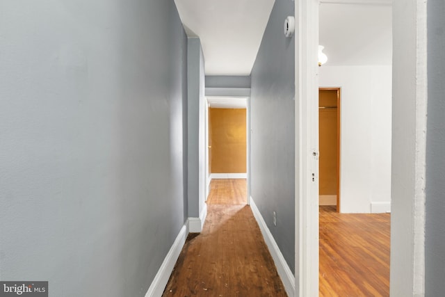 corridor with wood finished floors and baseboards