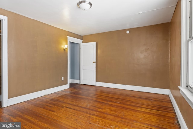 unfurnished room featuring baseboards and wood finished floors