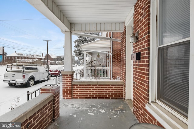 snow covered patio featuring a porch