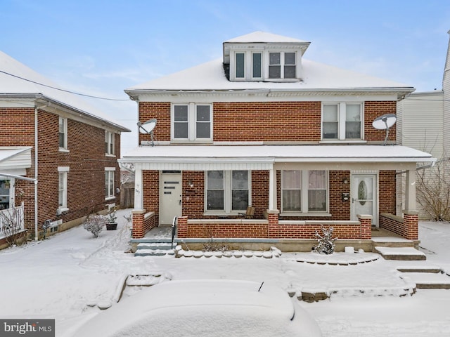 american foursquare style home featuring brick siding