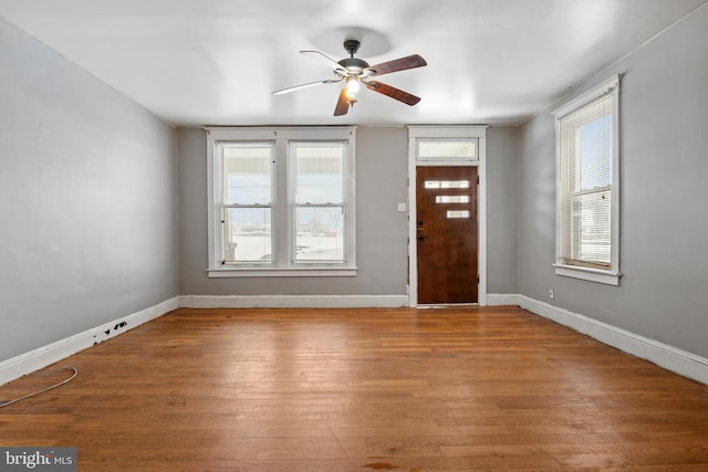 foyer with ceiling fan, baseboards, and wood finished floors