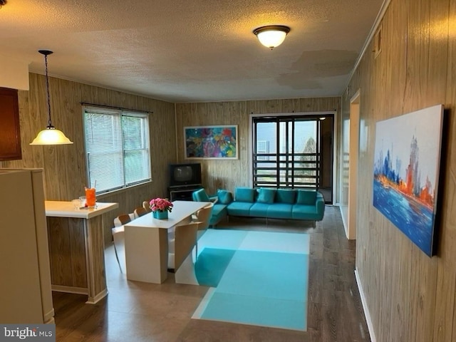 living room featuring a textured ceiling and wood walls