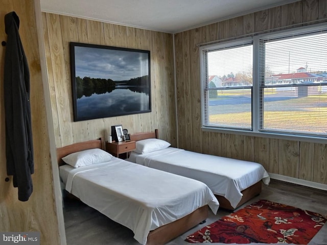 bedroom with hardwood / wood-style flooring and wooden walls