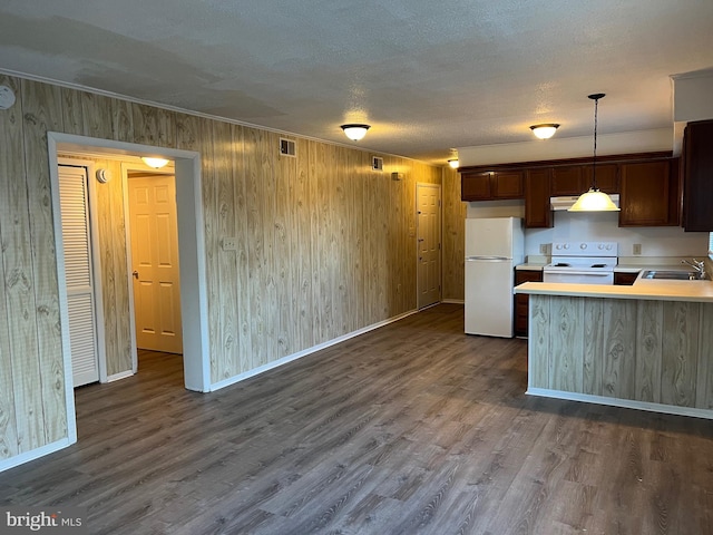 kitchen featuring white appliances, hanging light fixtures, dark hardwood / wood-style floors, a textured ceiling, and kitchen peninsula