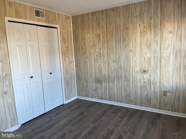 unfurnished bedroom featuring dark hardwood / wood-style floors and a closet