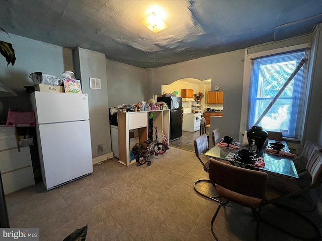 basement with black refrigerator and white fridge