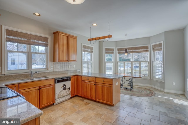 kitchen featuring kitchen peninsula, white dishwasher, light stone countertops, pendant lighting, and sink