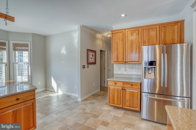 kitchen featuring decorative backsplash, stainless steel fridge with ice dispenser, and light stone counters