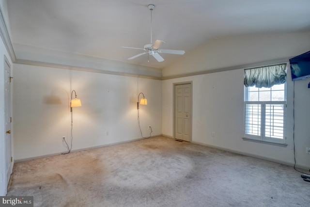 carpeted spare room with ceiling fan and vaulted ceiling