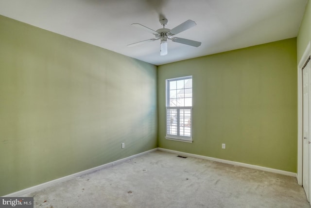 carpeted spare room with ceiling fan