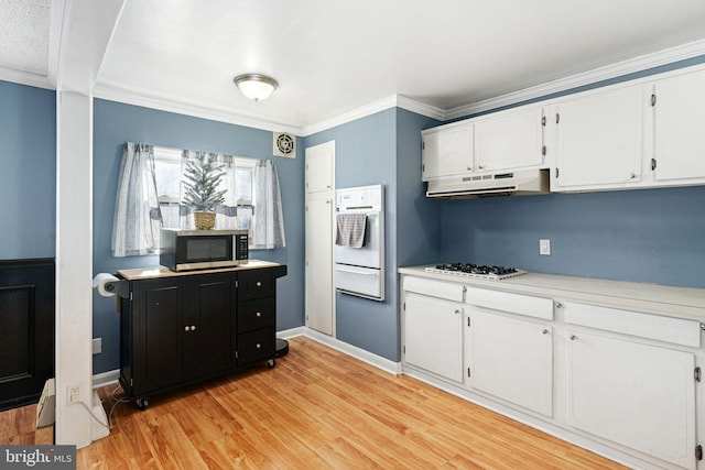 kitchen with white cabinets, white appliances, light hardwood / wood-style flooring, and crown molding