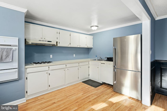 kitchen with light wood-type flooring, ornamental molding, white appliances, sink, and white cabinetry