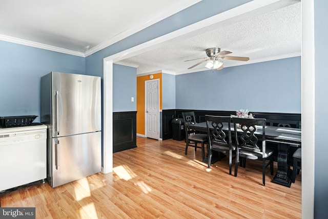 kitchen featuring stainless steel refrigerator, ceiling fan, dishwasher, light hardwood / wood-style flooring, and ornamental molding