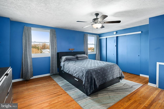 bedroom featuring hardwood / wood-style flooring, ceiling fan, and a textured ceiling