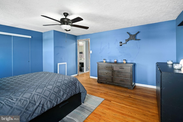 bedroom featuring ceiling fan, hardwood / wood-style floors, and a textured ceiling